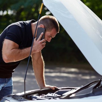 toco benefits vehicle service contracts provider man on the phone in front of car with open hood car trouble breakdown white car